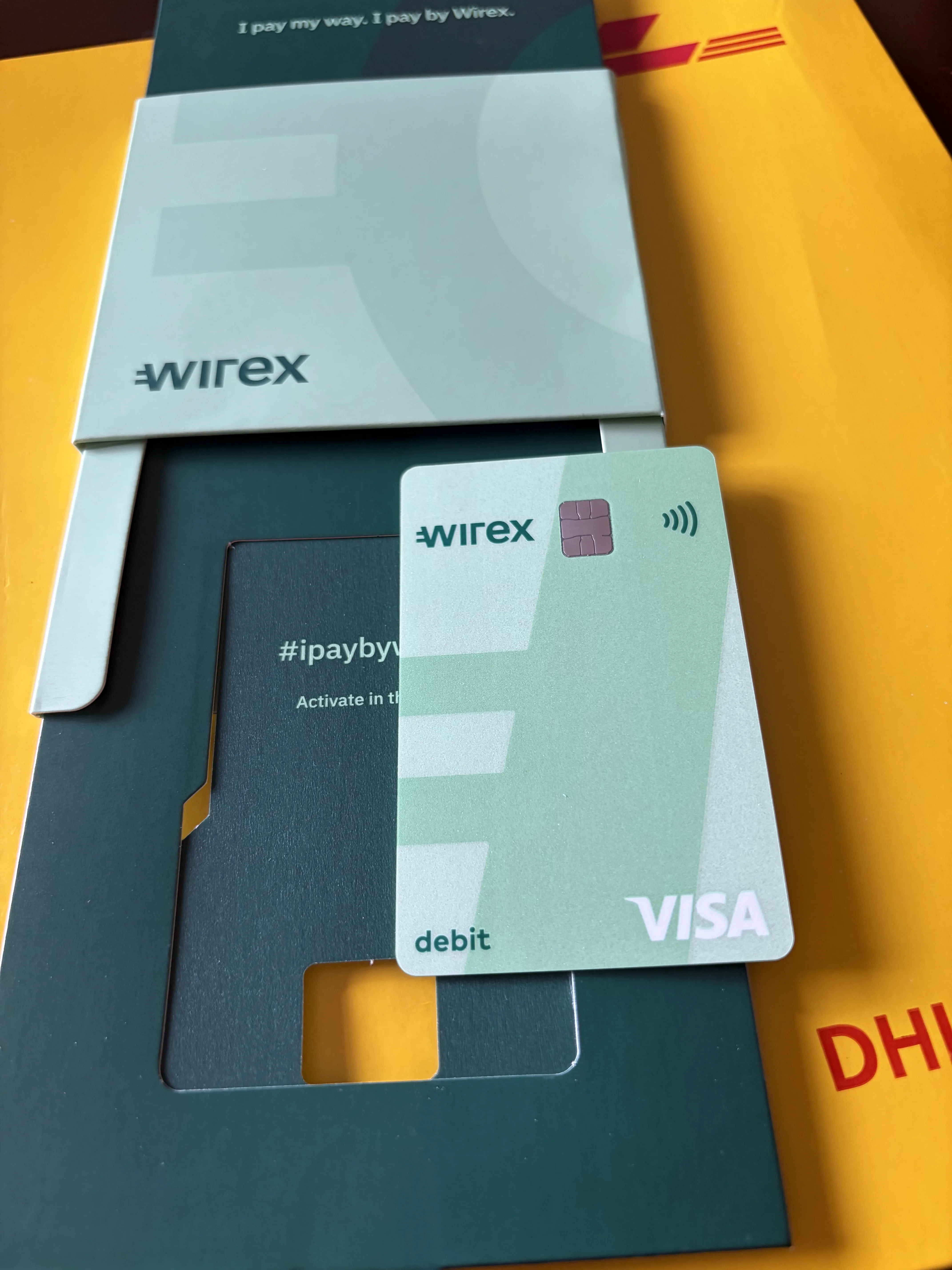 The green Wirex Visa debit card and its I pay by Wirex welcome sleeve